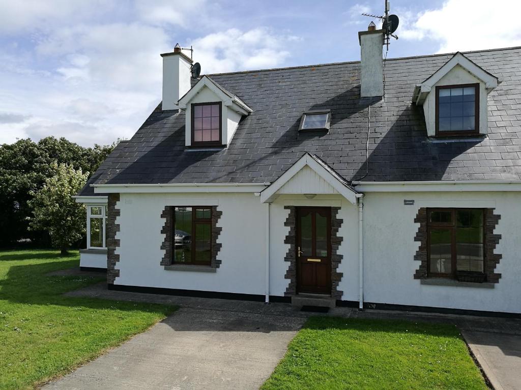 a white house with a black roof at Ban Milis 1 in Fethard on Sea