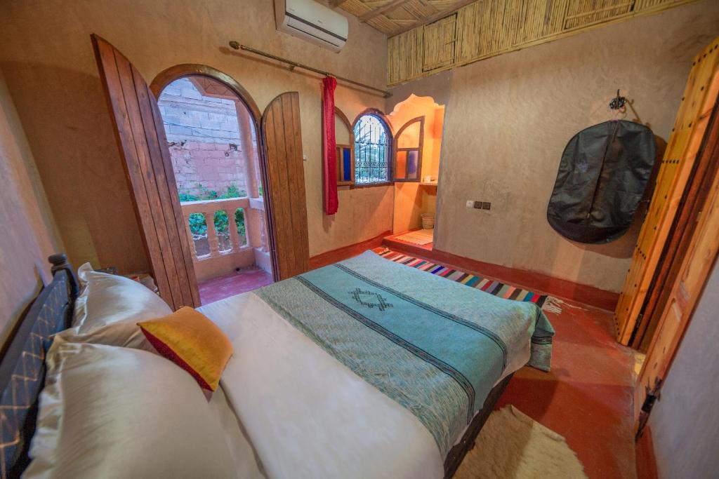 a bedroom with a bed in a room with a window at Dar nadia bendriss in Ouarzazate