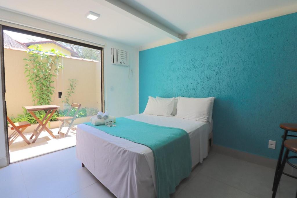 a bedroom with a bed with a blue wall at Bugio Flats in Abraão