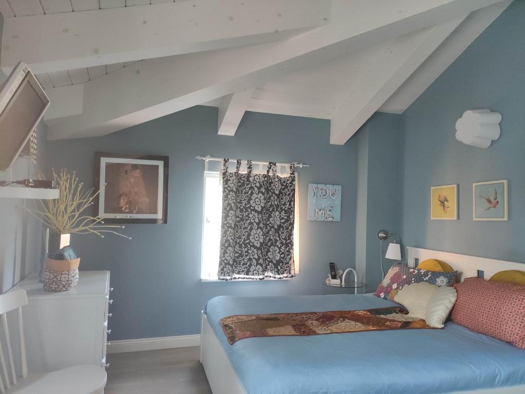 a bedroom with a bed with blue walls and a window at Ca' Moni - Imola in Imola
