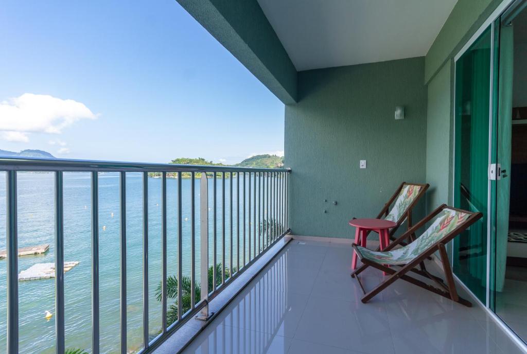 un balcón con 2 sillas y el océano en Paraíso Tropical! O mar é sua varanda! en Angra dos Reis