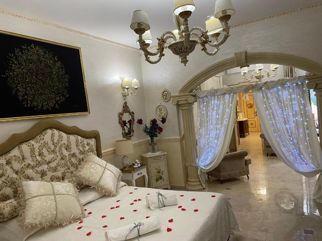 sypialnia z łóżkiem i żyrandolem w obiekcie Regina Suite w mieście Brindisi