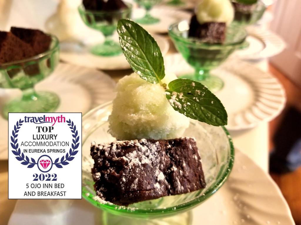 a plate with a chocolate cake with a green leaf on top at 5 Ojo Inn Bed and Breakfast in Eureka Springs