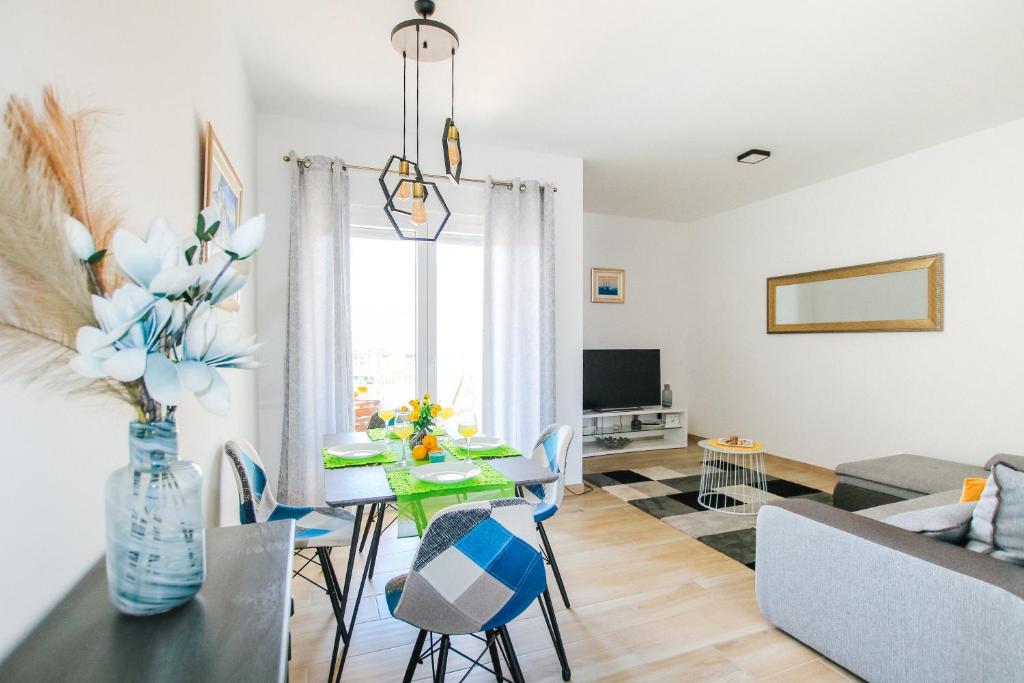 a dining room and living room with a table and chairs at Apartman Gaby in Trogir