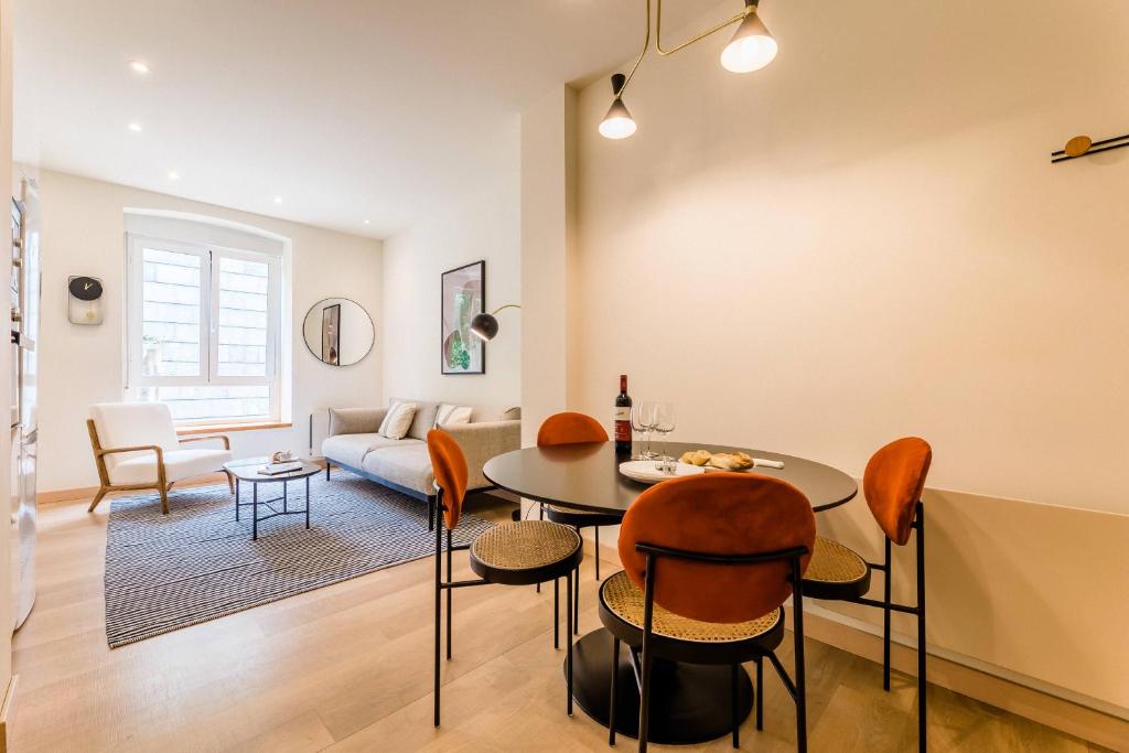 een woonkamer met een tafel en stoelen en een bank bij BARTOLOME Suite Apartment in San Sebastian