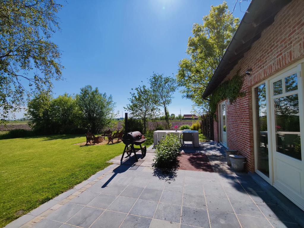 a patio with a table and a building at Cottage Moere in Koekelare