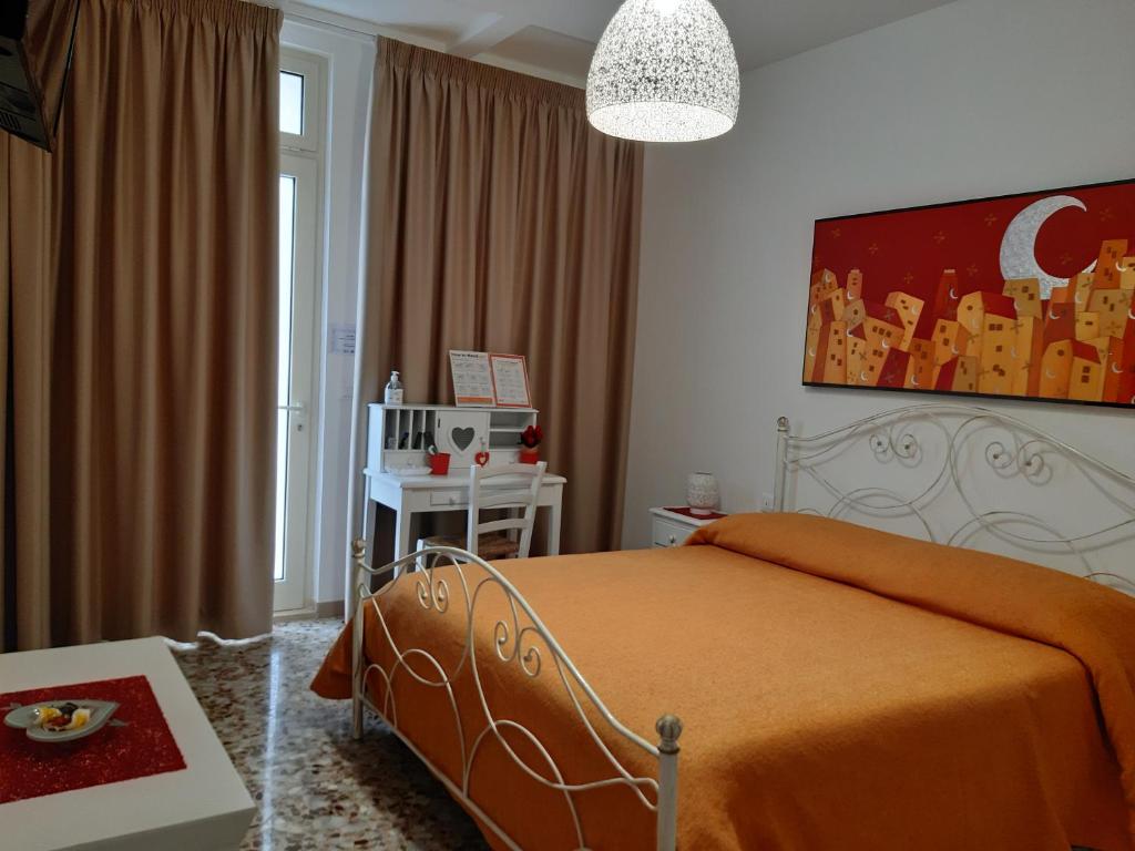 a bedroom with a bed with an orange blanket at Casa Mina affittacamere in Polignano a Mare