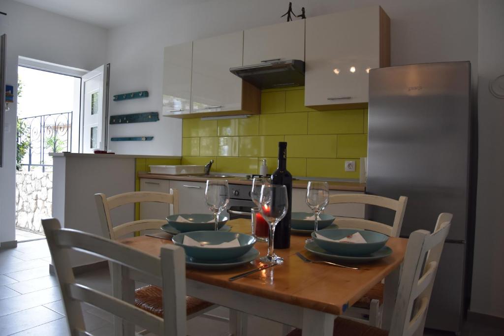 a kitchen with a wooden table with a bottle of wine at Apartman Vitamare 160 m from the beach in Novi Vinodolski