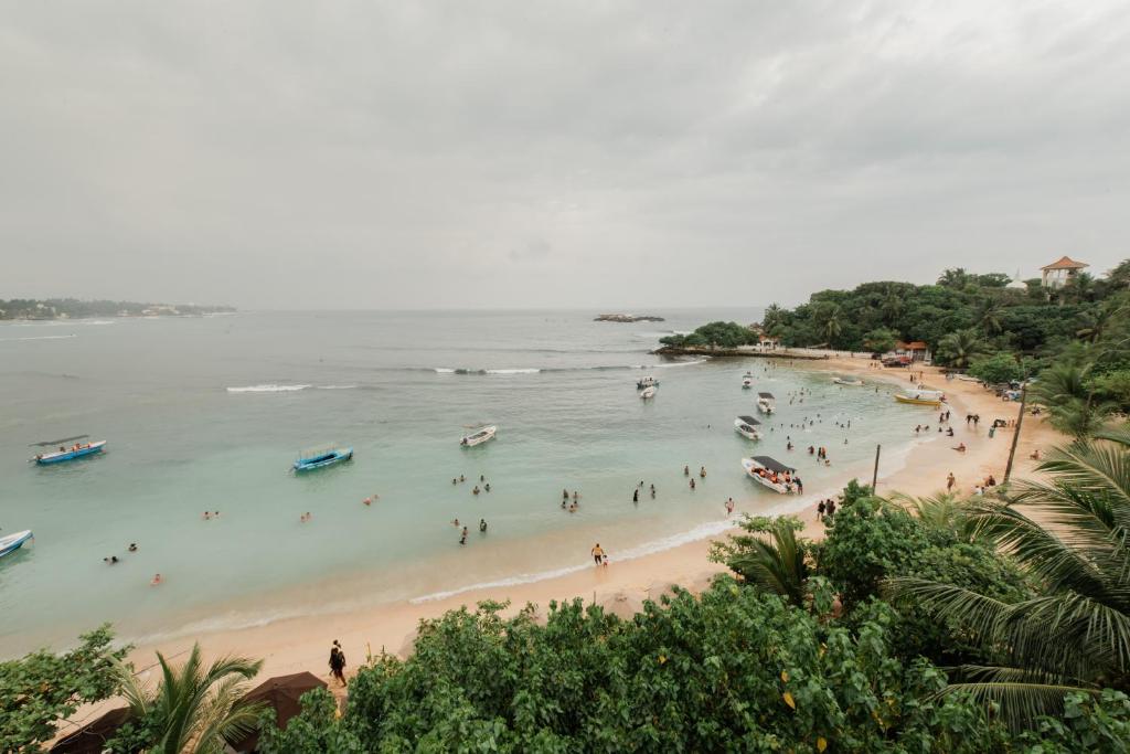 un groupe de personnes dans l'eau d'une plage dans l'établissement Seaview Deepal villa, à Unawatuna