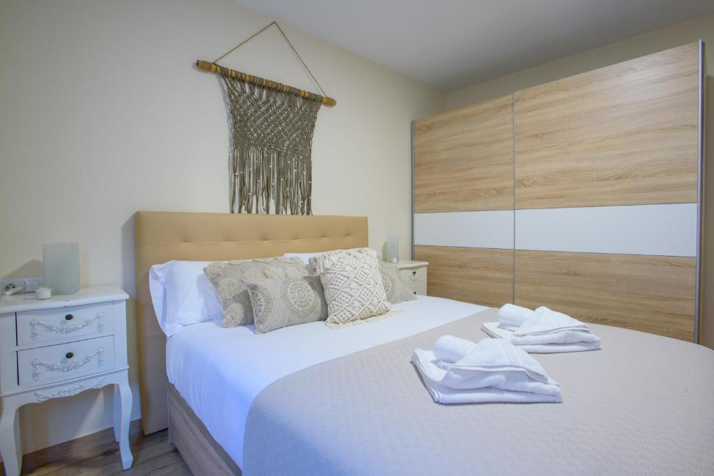 una camera da letto con un letto e asciugamani bianchi di Almansa Malaga Center a Málaga