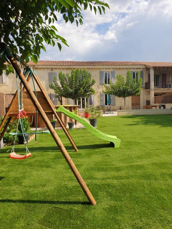 - une aire de jeux avec toboggan dans la cour dans l'établissement Mas provençal, à Mézoargues