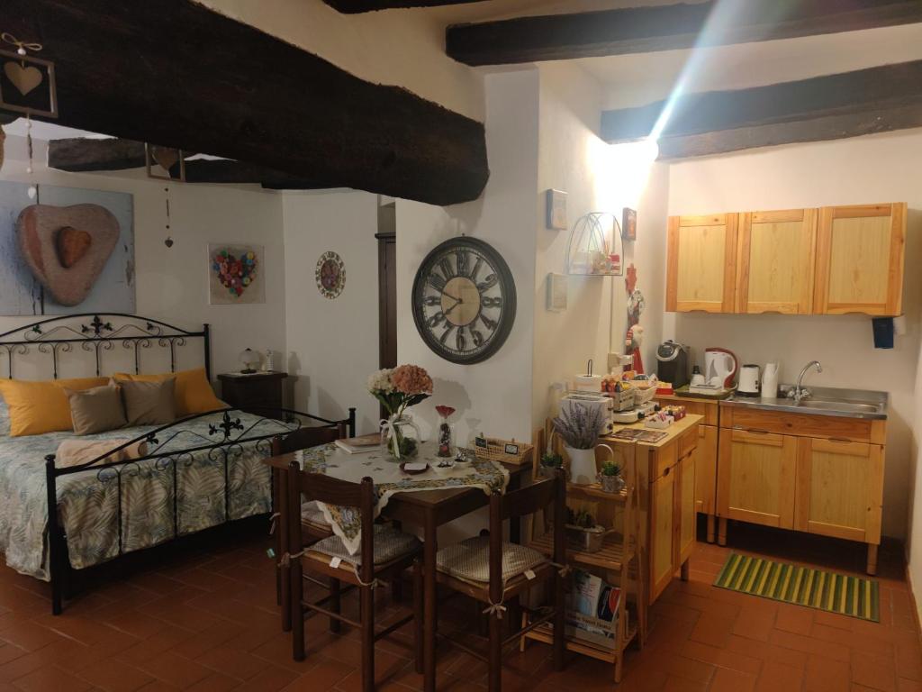a bedroom with a bed and a table and a kitchen at La Tana del Grillo in Pitigliano