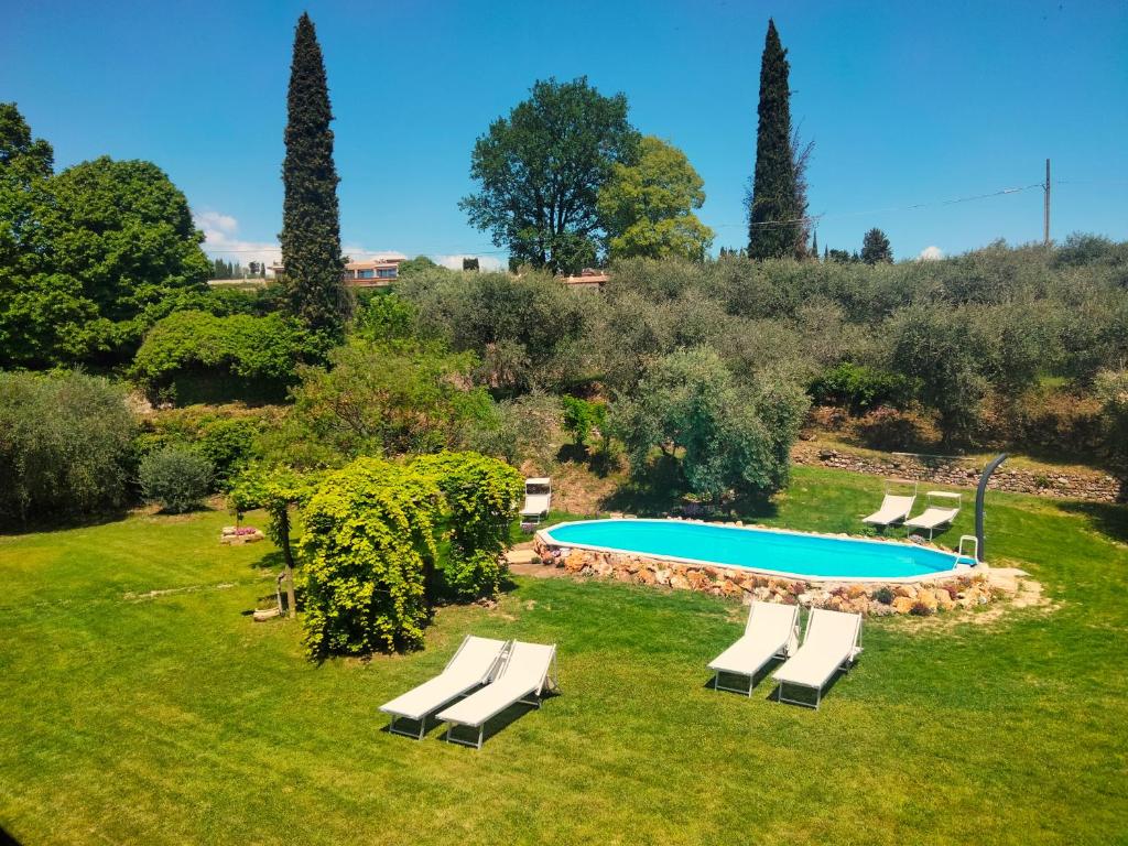 a swimming pool with lounge chairs in a yard at Agriturismo B&B Le Casette sul Garda in Cavaion Veronese