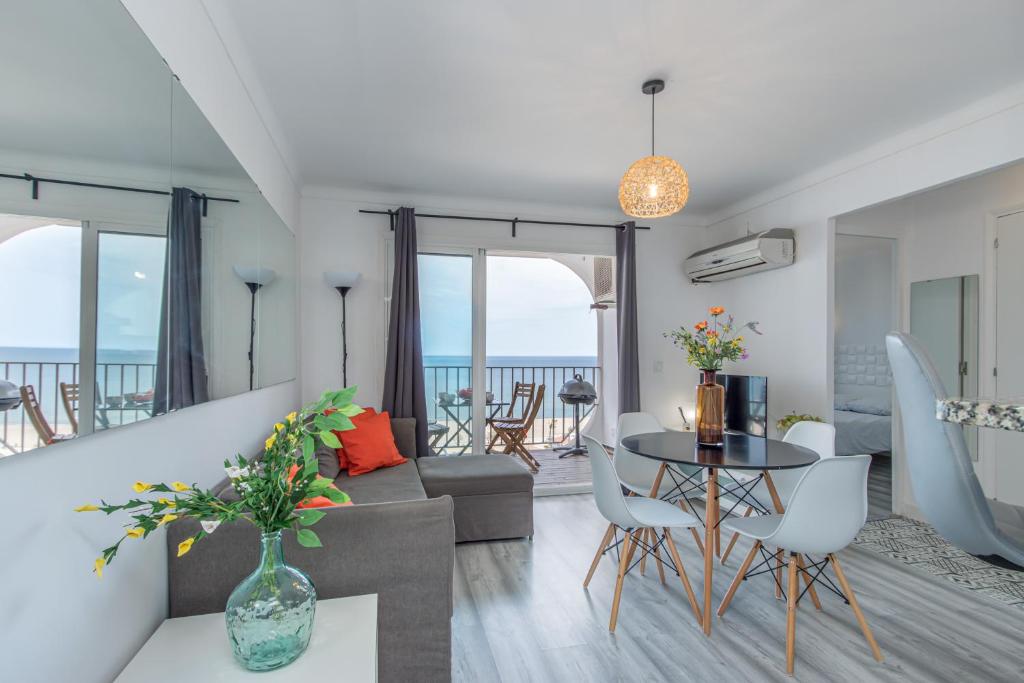 a living room with a couch and a table and chairs at BLUE HOLIDAYS RELAX & VIEWS Sylvia12 in Empuriabrava