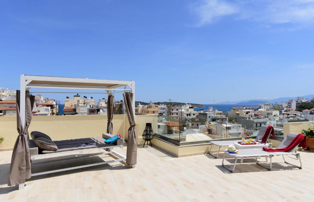 - un balcon sur le toit avec un lit et des chaises dans l'établissement Luxury Lake - Center House, à Agios Nikolaos