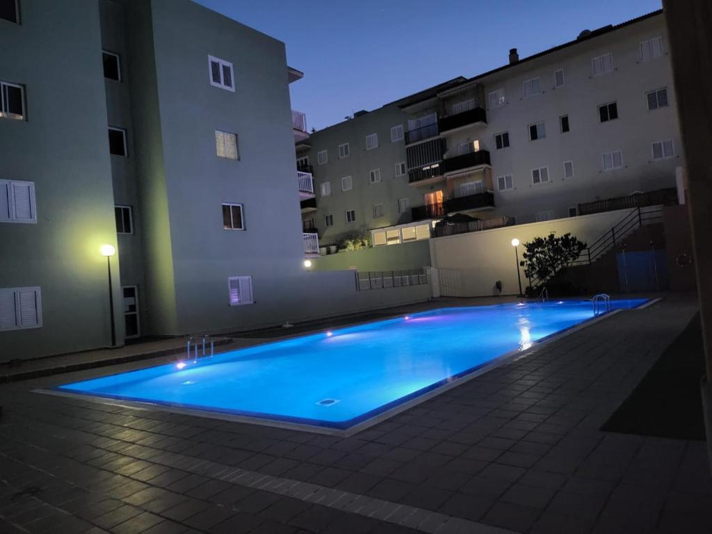 una piscina en medio de un edificio por la noche en Apartamento céntrico en Candelaria, con piscina., en Santa Cruz de Tenerife