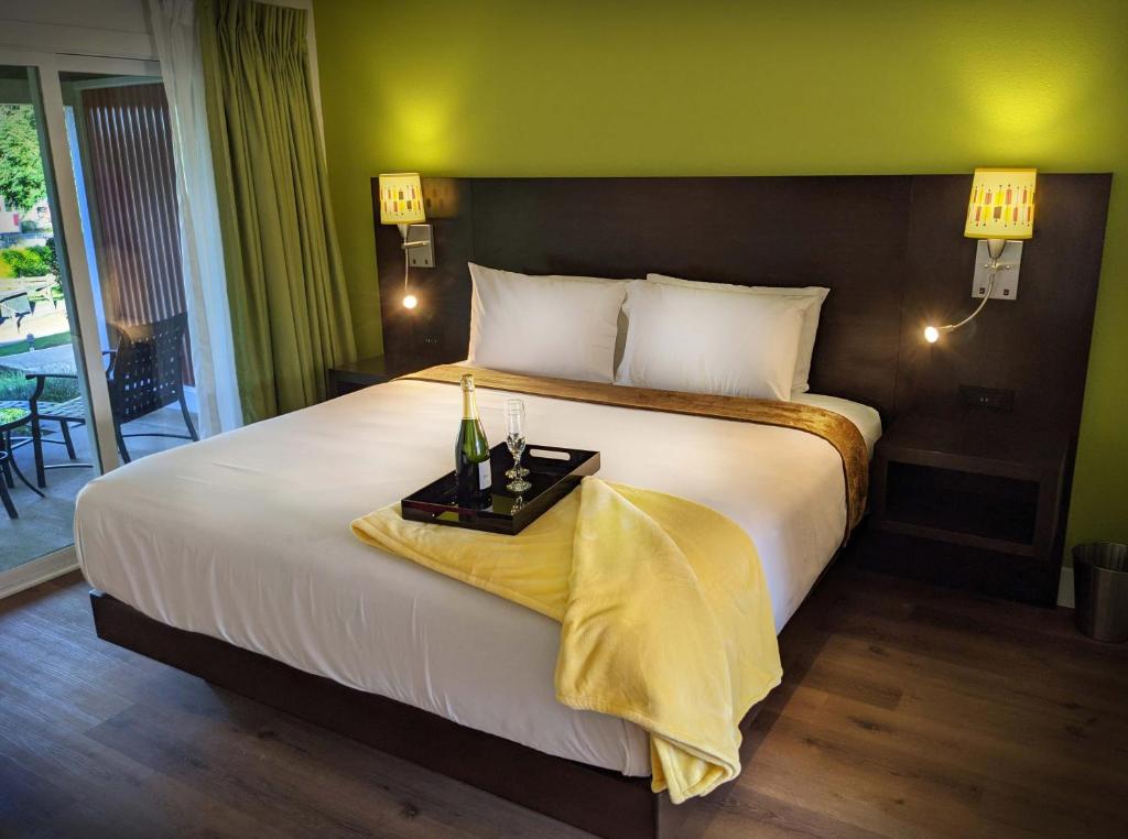 una camera da letto con un grande letto con una parete gialla di Foothills Motel ad Auburn
