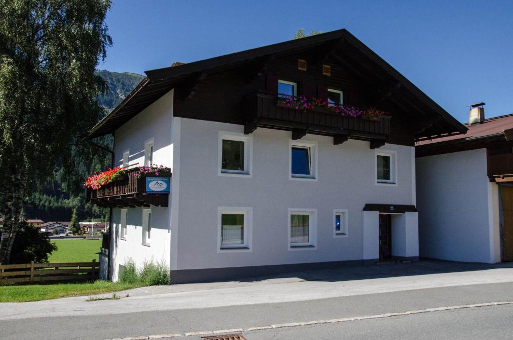 een wit gebouw met een balkon met bloemen erop bij Haus Therese in Kirchberg in Tirol