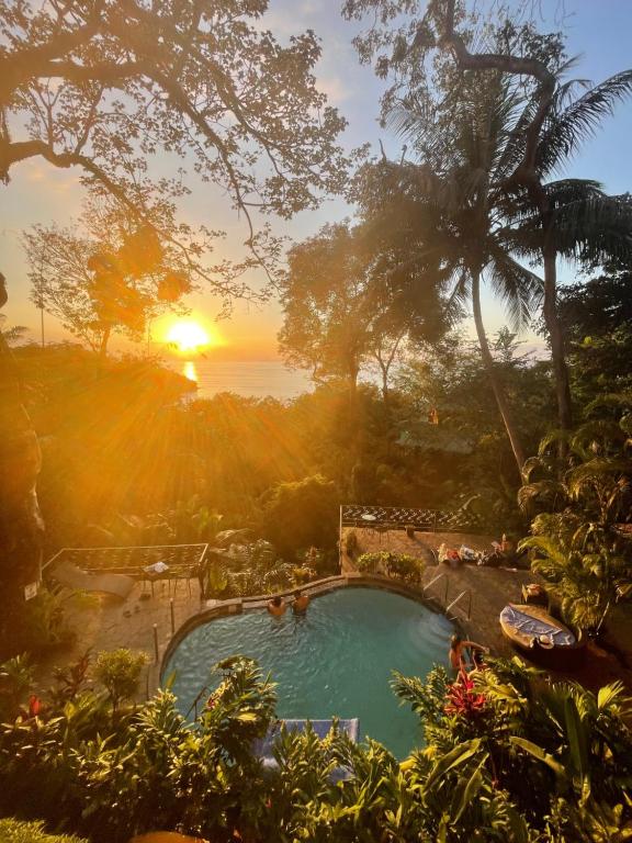 - une vue sur la piscine et le coucher de soleil en arrière-plan dans l'établissement Mango Moon Villa, à Manuel Antonio