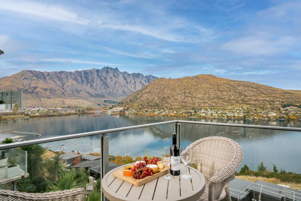 a table with a bowl of fruit on top of a balcony at Lakeview Retreat - Queenstown Holiday Home in Queenstown