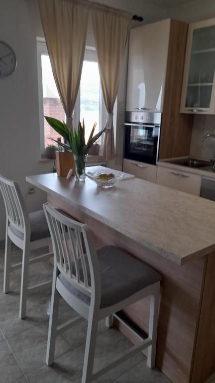 a kitchen with a table and two chairs and a counter at MERICA Kneže in Korčula