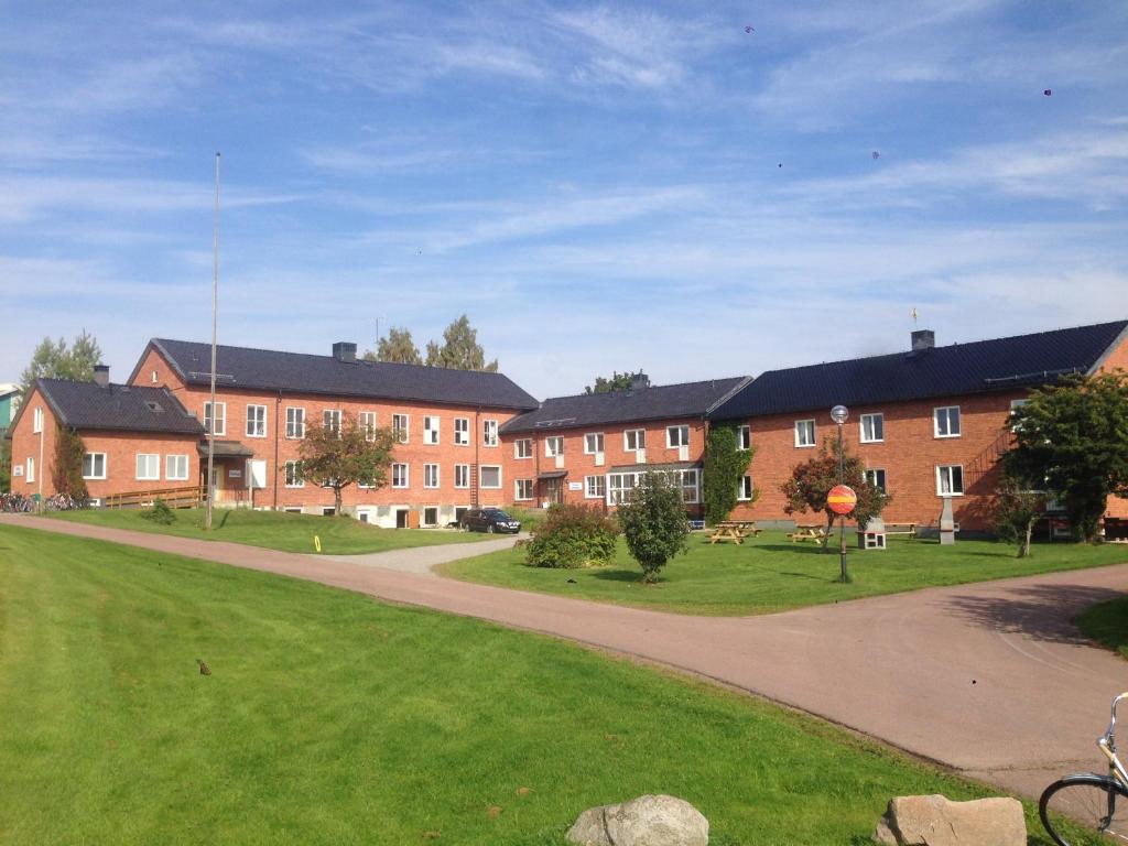 une rangée de bâtiments en briques dans un parc dans l'établissement Kullan, à Rättvik
