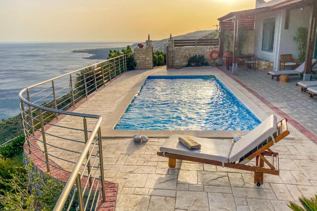 una piscina en la parte superior de una casa junto al océano en Maistros Villa, en Rodakino
