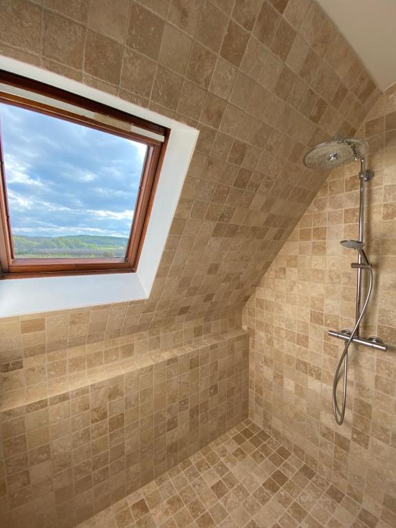 a bathroom with a shower with a window at Les Courtines - Appartement de caractère à la Roque-Gageac - Les Charmilles in La Roque-Gageac
