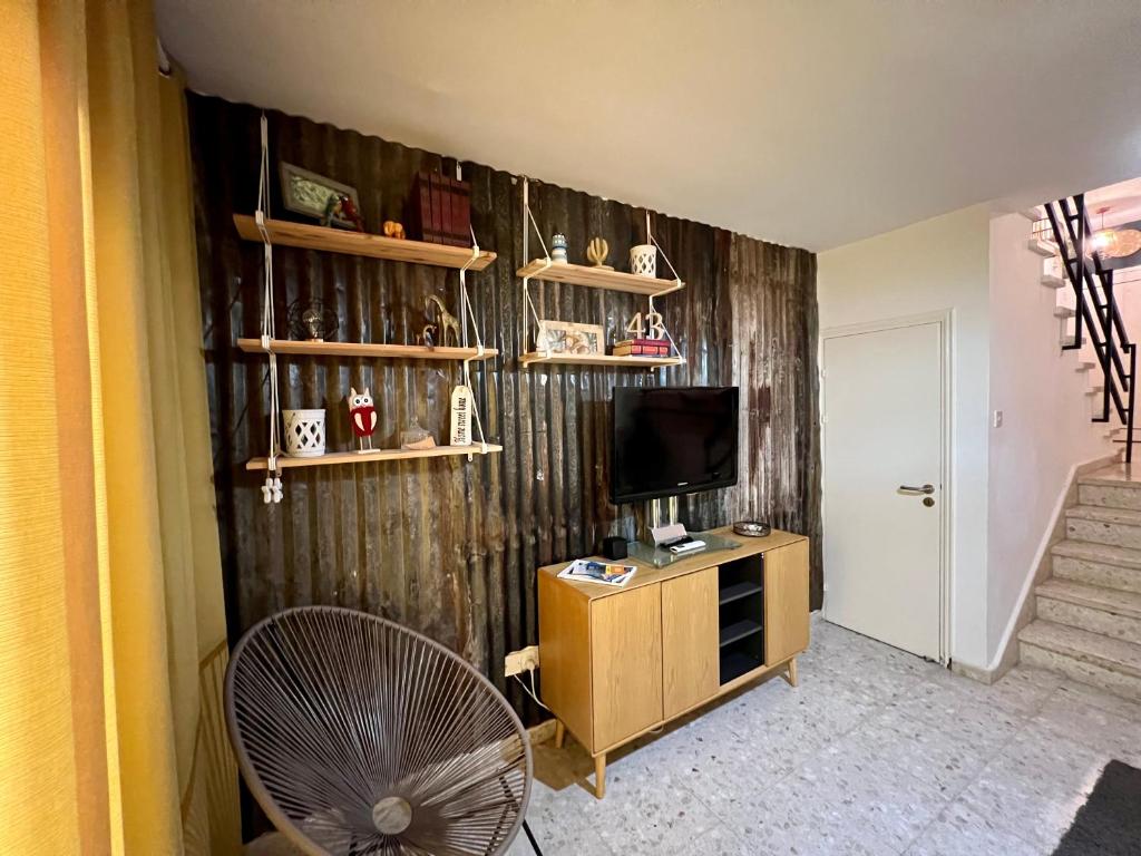 a living room with a television and a fan at FatCow Beach House 43 in Larnaka