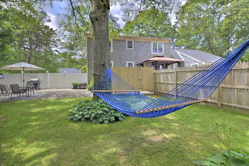 a blue hammock in a yard next to a fence at Cape Cod Getaway Fire Pit and Grill, 5 Mi to Beach! in Sandwich