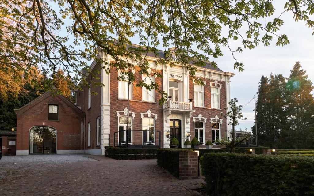 ein großes Backsteinhaus mit Torbogen in der Unterkunft Villa Polder in Gemert