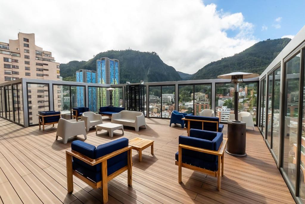 a balcony with chairs and tables on a building at CentralX 18 in Bogotá