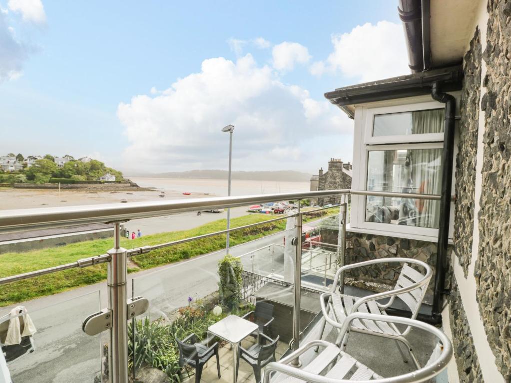 a balcony with chairs and a view of the ocean at 5 Ivy Terrace in Porthmadog