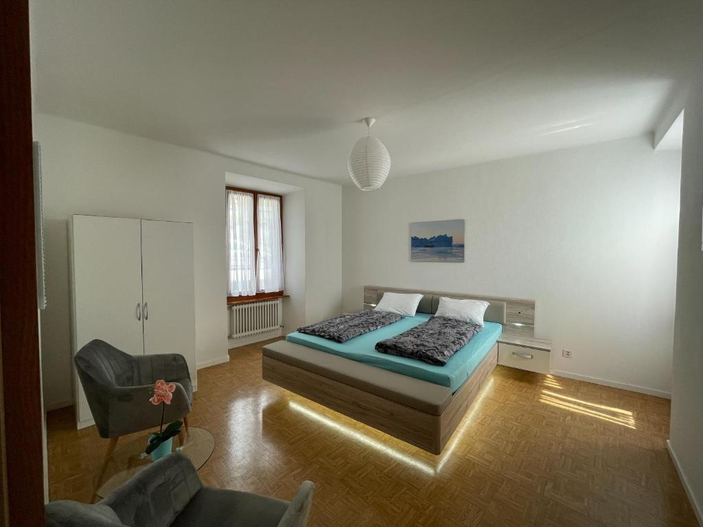 een slaapkamer met een bed en een stoel erin bij Residence Gaggiole, apartment 2 in Gordola