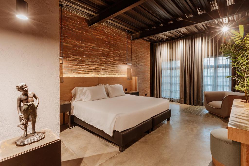 a bedroom with a bed and a couch and a chair at The Art Hotel El Poblado Medellín By Key 33 in Medellín