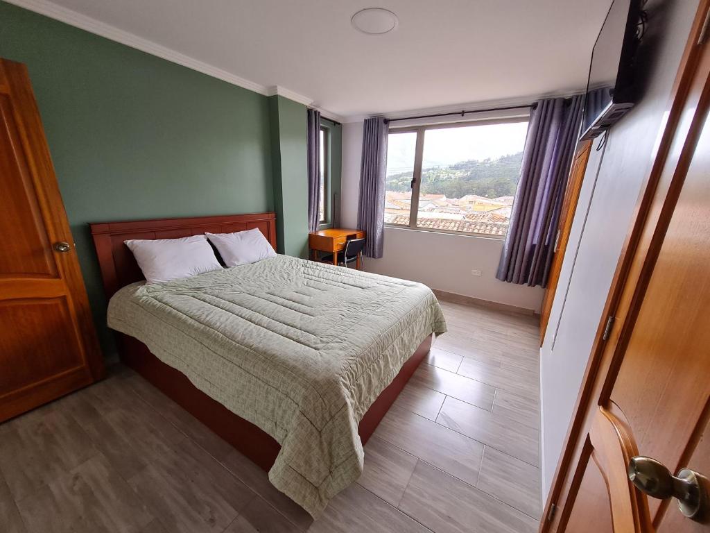 a bedroom with a bed and a window at Hostal Morlaquita in Cuenca