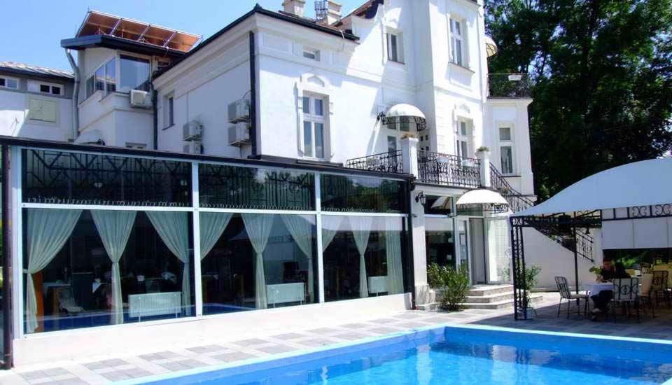 un hotel con piscina di fronte a un edificio di Devedzic a Vrnjačka Banja