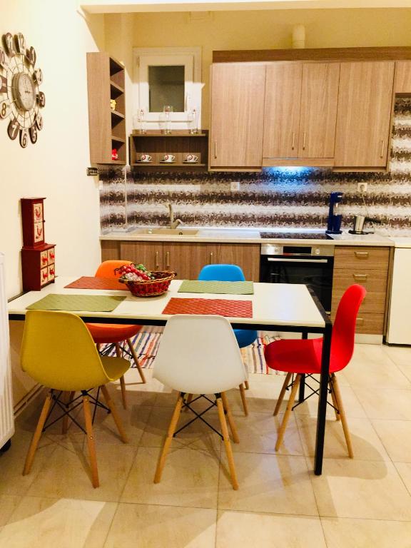 a kitchen with a table and colorful chairs at LuckyGeorge IsimeriaHomz in Thessaloniki