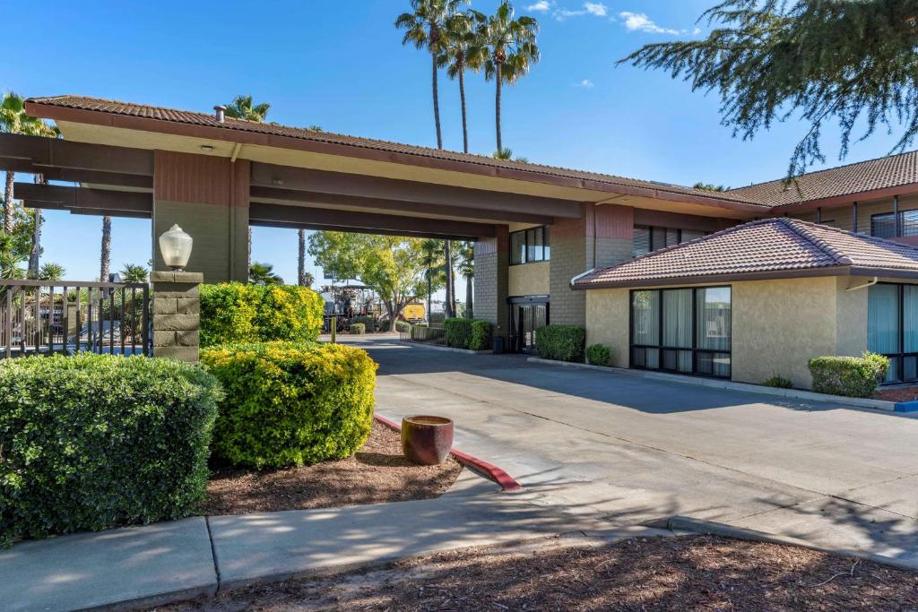 a building with bushes in front of a building at Best Western Orchard Inn in Turlock