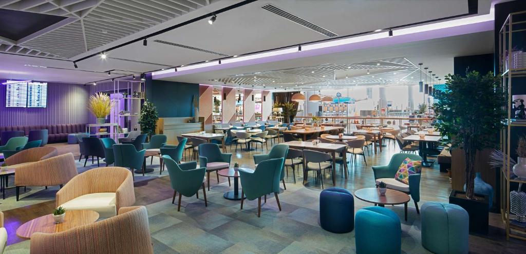 a restaurant with tables and chairs in a room at YOTEL Istanbul Airport, City Entrance in Istanbul