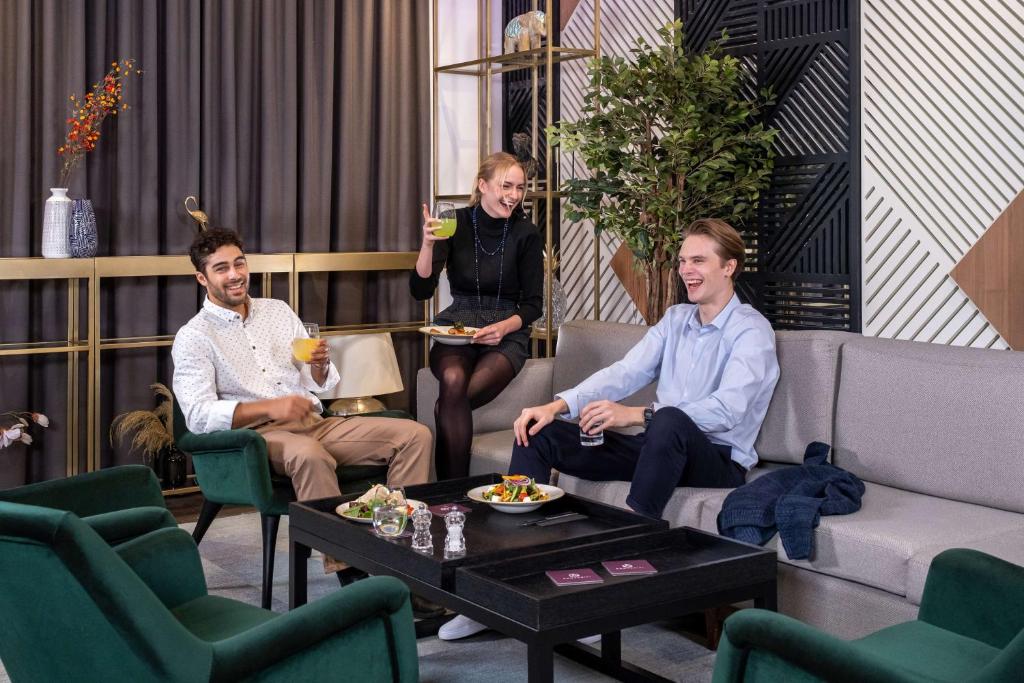 a group of three men sitting in a living room at YOTEL Istanbul Airport, City Entrance in Istanbul