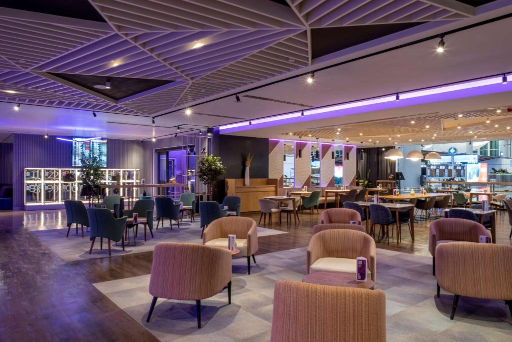 a restaurant with tables and chairs in a room at YOTEL Istanbul Airport, City Entrance in Istanbul