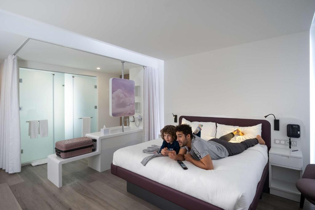 a man and a boy laying on a bed at YOTEL Istanbul Airport, City Entrance in Istanbul