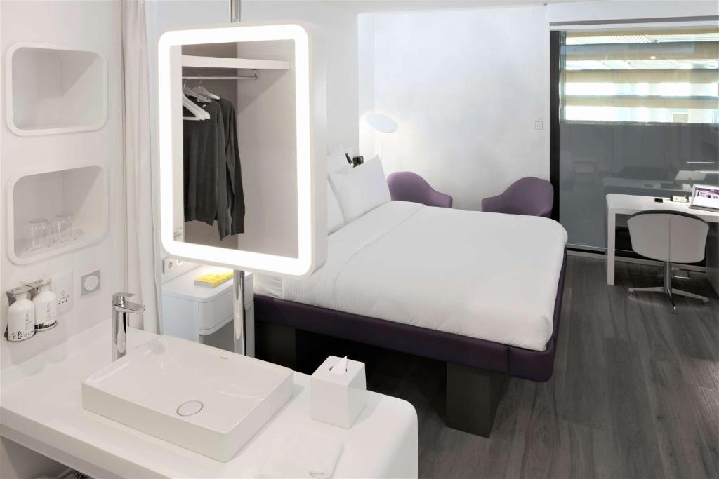 a room with a bed and a sink and a mirror at YOTEL Istanbul Airport, City Entrance in Istanbul