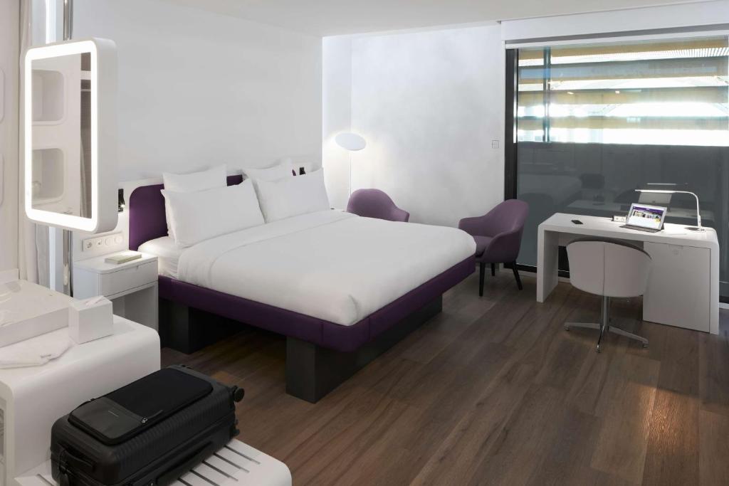 a bedroom with a bed and a desk with a suitcase at YOTEL Istanbul Airport, City Entrance in Istanbul