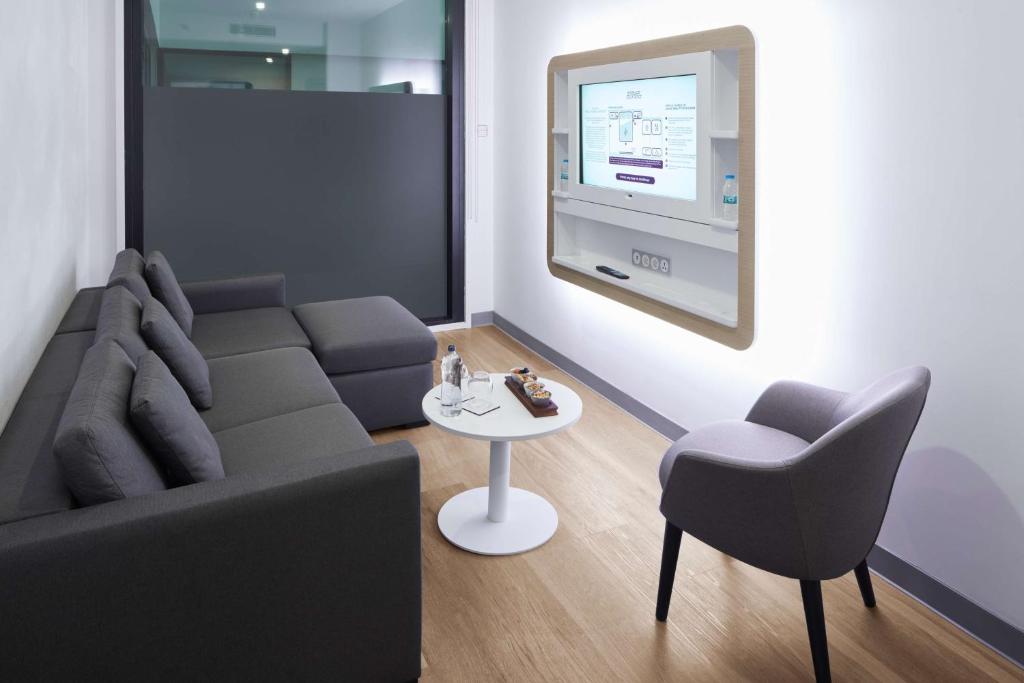 a living room with a couch and a chair and a table at YOTEL Istanbul Airport, City Entrance in Istanbul
