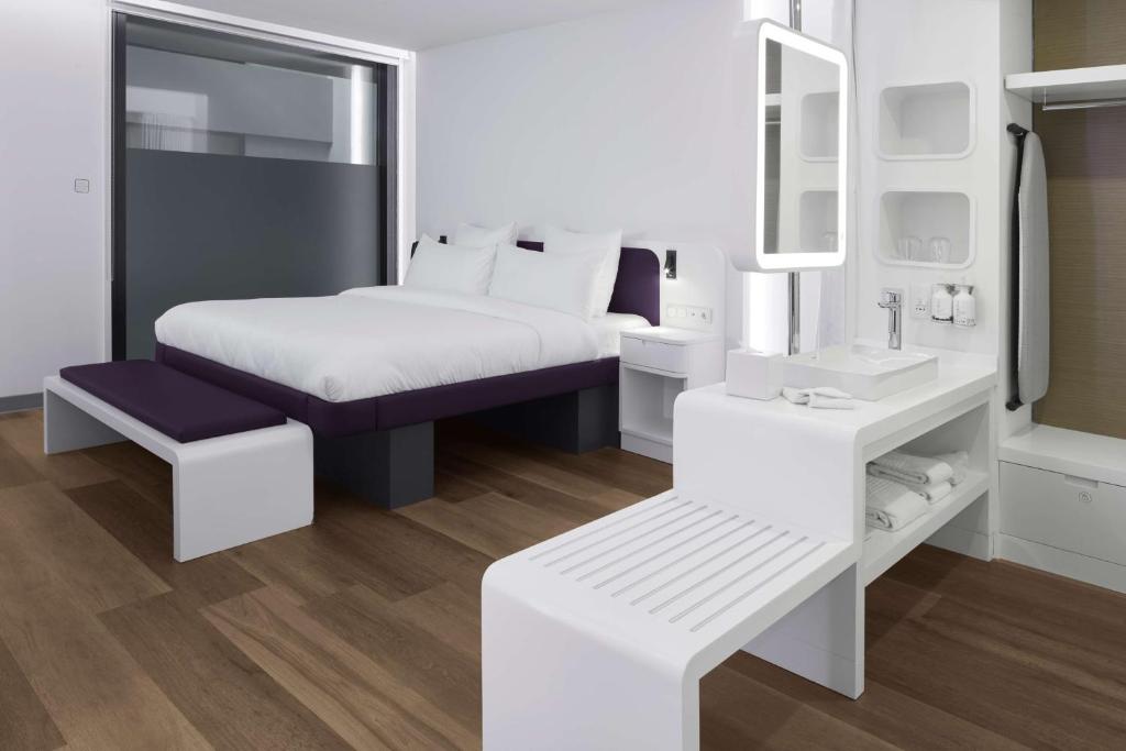 a white bedroom with a bed and a mirror at YOTEL Istanbul Airport, City Entrance in Istanbul