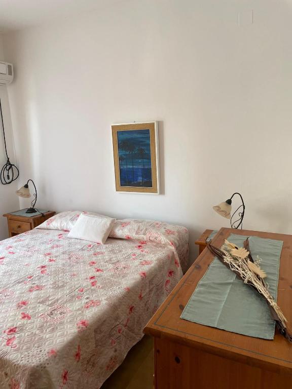 a bedroom with a bed and a wooden table at Incantevole appartamento Sole, in centro in Stintino