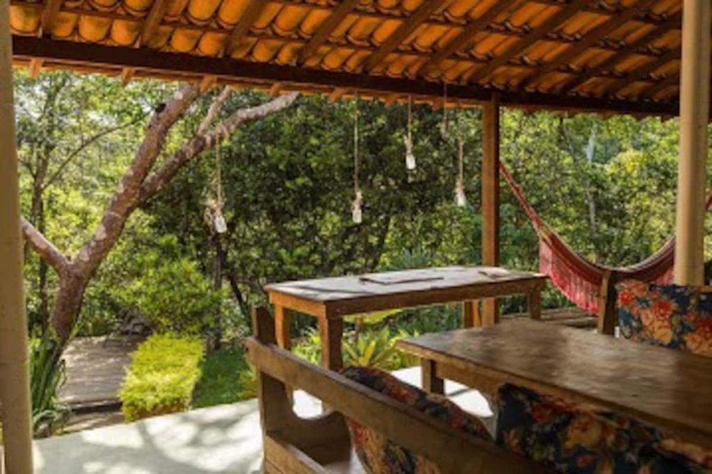 un patio con una mesa y una hamaca en un porche en Pousada Canto Feliz, en Serra do Cipo