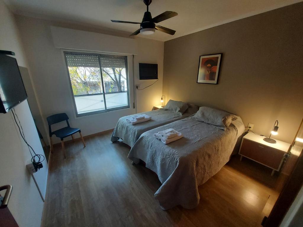 Schlafzimmer mit einem Bett und einem Deckenventilator in der Unterkunft Castellanos Departamento Temporario in Santa Fe